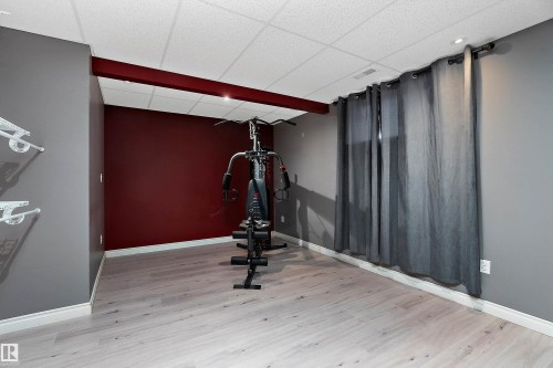 Exercise room with a paneled ceiling and light wood-style flooring - 33 Sutherland Street, Leduc, AB - Indoor