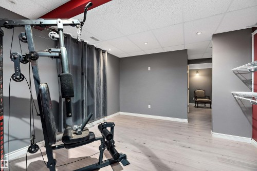Exercise room with a drop ceiling and light wood-type flooring - 33 Sutherland Street, Leduc, AB - Indoor Photo Showing Gym Room