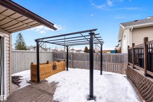 Snow covered patio with a deck and a fenced backyard - 33 Sutherland Street, Leduc, AB - Outdoor With Deck Patio Veranda With Exterior