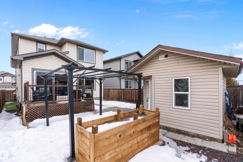 Snow covered property featuring a garden, a fenced backyard, and a wooden deck - 33 Sutherland Street, Leduc, AB - Outdoor With Deck Patio Veranda With Exterior