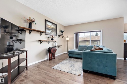 Living area with wood finished floors and a textured ceiling - 33 Sutherland Street, Leduc, AB - Indoor Photo Showing Living Room