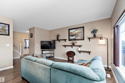 Living room featuring dark wood-type flooring and plenty of natural light - 33 Sutherland Street, Leduc, AB - Indoor Photo Showing Living Room