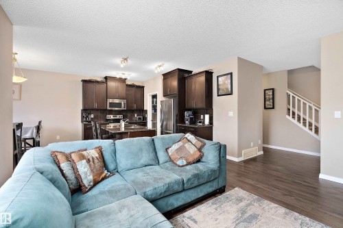 Living area with dark wood-style flooring and a textured ceiling - 33 Sutherland Street, Leduc, AB - Indoor Photo Showing Living Room