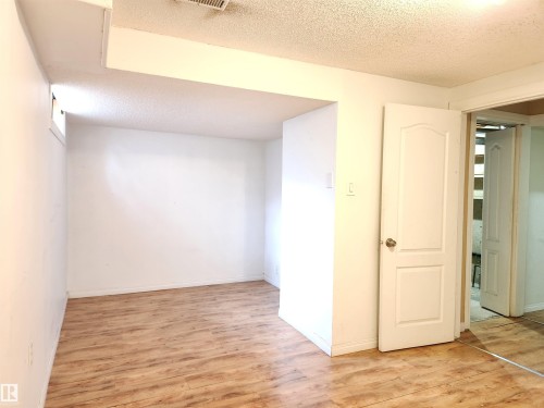 Spare room with a textured ceiling and light wood finished floors - 6 14320 80 Street, Edmonton, AB - Indoor Photo Showing Other Room
