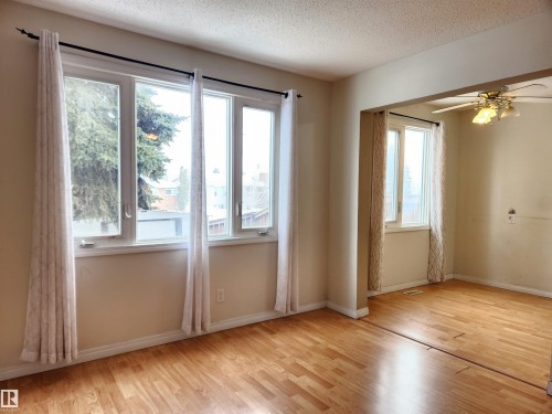 Unfurnished room featuring a ceiling fan, light wood finished floors, and a textured ceiling - 6 14320 80 Street, Edmonton, AB - Indoor Photo Showing Other Room