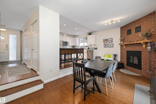 Dining area with dark wood-style flooring and a fireplace - 12 Beacon Crescent, St. Albert, AB - Indoor With Fireplace