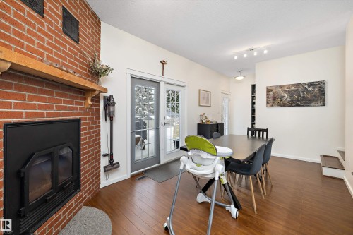 Dining area with dark wood finished floors, a wood stove, and a textured ceiling - 12 Beacon Crescent, St. Albert, AB - Indoor With Fireplace
