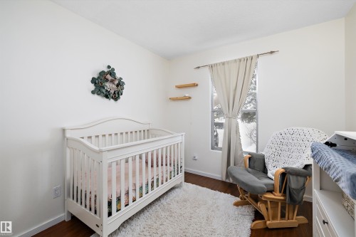 Bedroom with a crib and dark wood-type flooring - 12 Beacon Crescent, St. Albert, AB - Indoor Photo Showing Bedroom