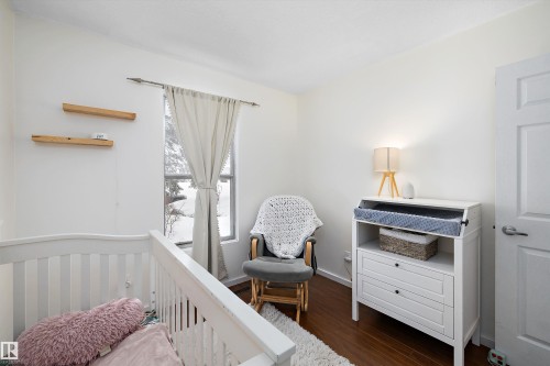 Bedroom featuring dark wood finished floors and a nursery area - 12 Beacon Crescent, St. Albert, AB - Indoor Photo Showing Bedroom