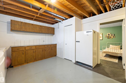 Unfinished basement with freestanding refrigerator and wooden walls - 12 Beacon Crescent, St. Albert, AB - Indoor Photo Showing Basement
