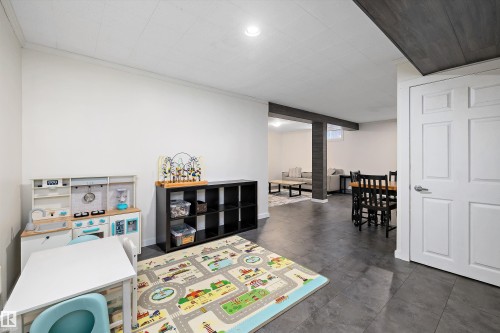 Recreation room featuring recessed lighting, ornamental molding, and dark tile patterned flooring - 12 Beacon Crescent, St. Albert, AB - Indoor