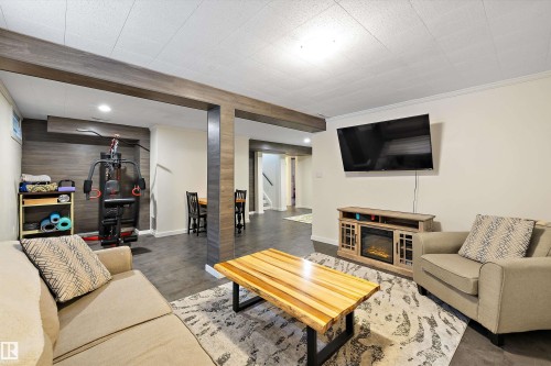 Living area with stairway and wooden walls - 12 Beacon Crescent, St. Albert, AB - Indoor Photo Showing Living Room With Fireplace