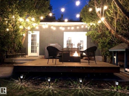 Deck at night with an outdoor fire pit, french doors, and grilling area - 12 Beacon Crescent, St. Albert, AB - Outdoor With Deck Patio Veranda