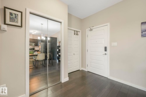 Foyer entrance featuring dark wood-type flooring and baseboards - 122 304 Ambleside Link Link, Edmonton, AB - Indoor Photo Showing Other Room