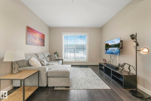 Living area with baseboards and dark wood finished floors - 122 304 Ambleside Link Link, Edmonton, AB - Indoor Photo Showing Living Room