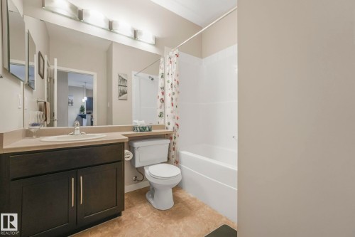 Full bathroom featuring vanity and shower / bathtub combination with curtain - 122 304 Ambleside Link Link, Edmonton, AB - Indoor Photo Showing Bathroom