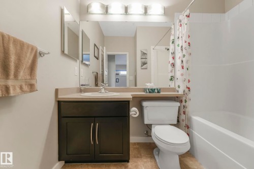 Full bathroom featuring vanity, shower / tub combo, and light tile patterned floors - 122 304 Ambleside Link Link, Edmonton, AB - Indoor Photo Showing Bathroom