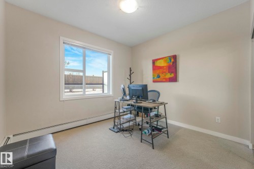 Office area featuring a baseboard heating unit and light carpet - 122 304 Ambleside Link Link, Edmonton, AB - Indoor Photo Showing Office