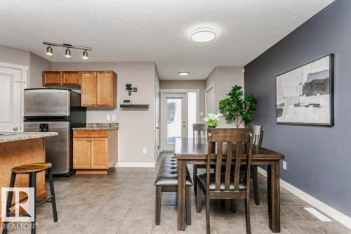 Dining area with a textured ceiling and light tile patterned floors - 1381 Rutherford Road, Edmonton, AB - Indoor