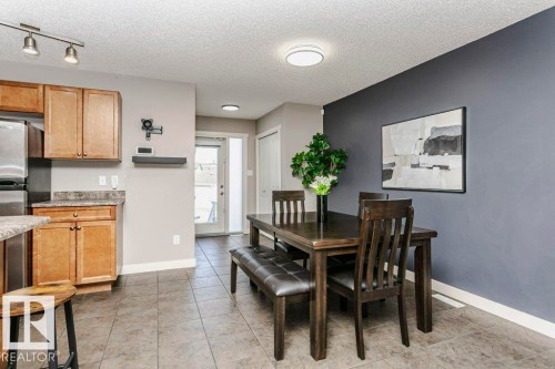 Dining area with a textured ceiling, light tile patterned floors, and rail lighting - 1381 Rutherford Road, Edmonton, AB - Indoor