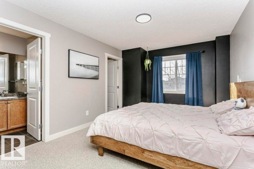 Bedroom with dark colored carpet, a textured ceiling, and dark tile patterned floors - 1381 Rutherford Road, Edmonton, AB - Indoor Photo Showing Bedroom