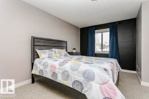 Carpeted bedroom featuring baseboards and a textured ceiling - 1381 Rutherford Road, Edmonton, AB - Indoor Photo Showing Bedroom