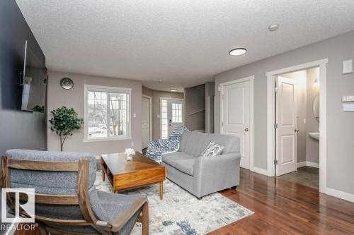 Living area featuring dark wood finished floors and a textured ceiling - 1381 Rutherford Road, Edmonton, AB - Indoor Photo Showing Living Room