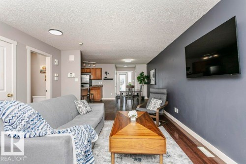 Living room with wood finished floors and a textured ceiling - 1381 Rutherford Road, Edmonton, AB - Indoor Photo Showing Living Room