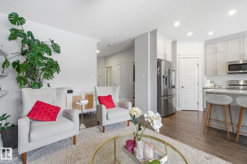 Living area featuring dark wood-style flooring, recessed lighting, and a textured ceiling - 9942 222A St Nw, Edmonton, AB - Indoor