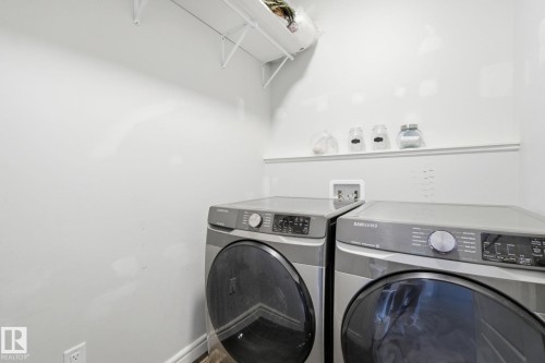 Laundry area featuring separate washer and dryer and baseboards - 9942 222A St Nw, Edmonton, AB - Indoor Photo Showing Laundry Room