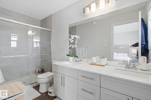 Ensuite bathroom featuring double vanity, a shower stall, and dark wood finished floors - 9942 222A St Nw, Edmonton, AB - Indoor Photo Showing Bathroom