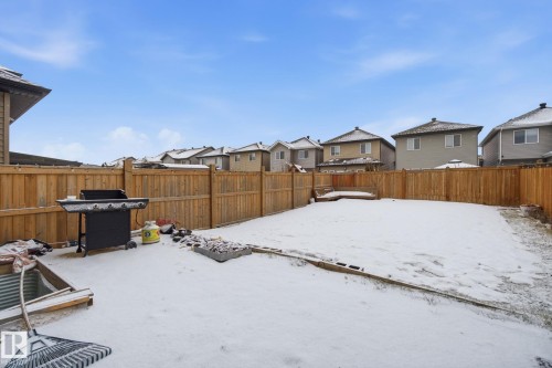 Snowy yard featuring a residential view and a fenced backyard - 9942 222A St Nw, Edmonton, AB - Outdoor