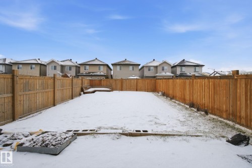 Yard covered in snow with a residential view and a fenced backyard - 9942 222A St Nw, Edmonton, AB - Outdoor
