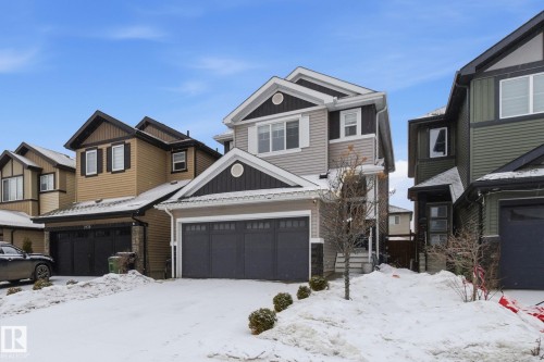 Craftsman-style home featuring board and batten siding, an attached garage, and a residential view - 9942 222A St Nw, Edmonton, AB - Outdoor With Facade