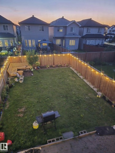 Yard at dusk with a residential view and a fenced backyard - 9942 222A St Nw, Edmonton, AB - Outdoor