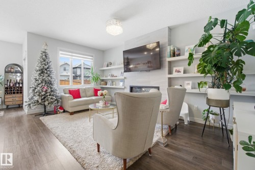 Living room featuring dark wood-type flooring and a fireplace - 9942 222A St Nw, Edmonton, AB - Indoor Photo Showing Living Room