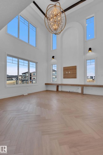 Unfurnished living room featuring hanging lights, a high ceiling, and parquet floors - 463 Crystal Creek Link, Leduc, AB - Indoor Photo Showing Other Room