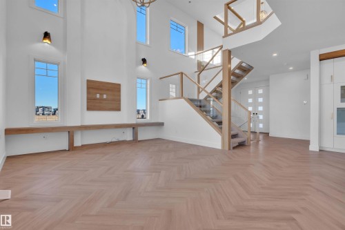 Unfurnished living room with parquet flooring, healthy amount of natural light, and a high ceiling - 463 Crystal Creek Link, Leduc, AB - Indoor Photo Showing Other Room