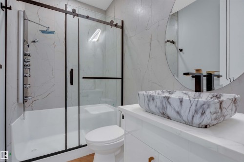 Full bathroom with vanity, a marble finish shower, and stone wall - 463 Crystal Creek Link, Leduc, AB - Indoor Photo Showing Bathroom
