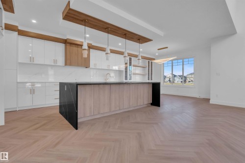 Dual tone kitchen with two tone color scheme, modern cabinets, a kitchen island, open shelves, and pendant lighting - 463 Crystal Creek Link, Leduc, AB - Indoor Photo Showing Kitchen