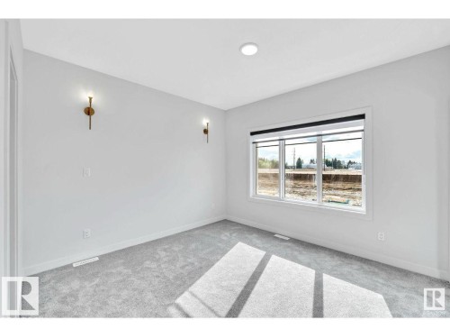 Spare room with light carpet and baseboards - 426 Crystal Creek Link, Leduc, AB - Indoor Photo Showing Other Room