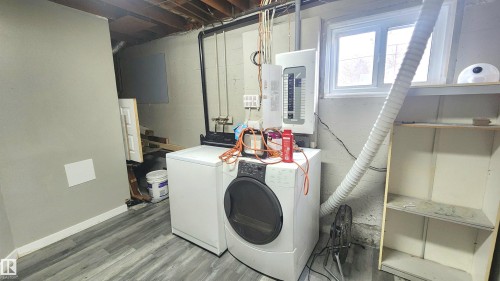 Laundry area featuring electric panel, washer and clothes dryer, and wood finished floors - 12139 81 Street, Edmonton, AB - Indoor Photo Showing Laundry Room