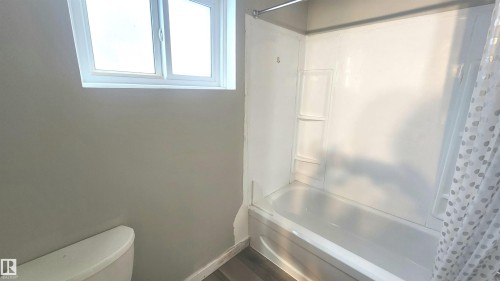 Bathroom with bathing tub / shower combination and baseboards - 12139 81 Street, Edmonton, AB - Indoor Photo Showing Bathroom