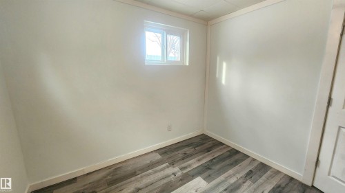 Unfurnished room featuring baseboards and wood finished floors - 12139 81 Street, Edmonton, AB - Indoor Photo Showing Other Room