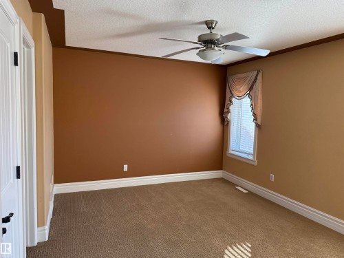 Unfurnished bedroom featuring carpet flooring, a textured ceiling, and ceiling fan - 816 Wildwood Crescent Nw, Edmonton, AB - Indoor Photo Showing Other Room