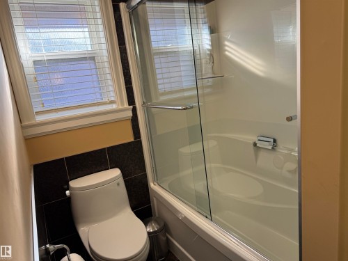 Bathroom featuring tile walls and combined bath / shower with glass door - 816 Wildwood Crescent Nw, Edmonton, AB - Indoor Photo Showing Bathroom