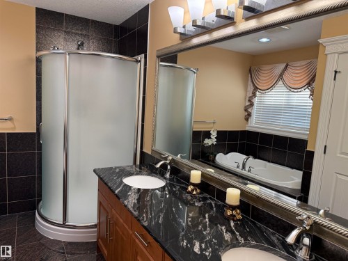 Full bath with double vanity, a stall shower, a garden tub, dark tile patterned floors, and tile walls - 816 Wildwood Crescent Nw, Edmonton, AB - Indoor Photo Showing Bathroom