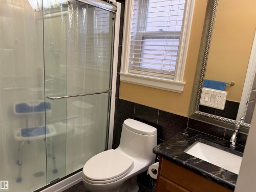 Bathroom featuring tile walls, vanity, a stall shower, and wainscoting - 816 Wildwood Crescent Nw, Edmonton, AB - Indoor Photo Showing Bathroom