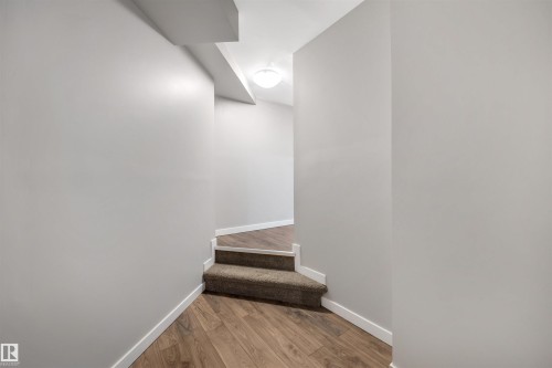 Staircase featuring wood finished floors - 81 Richmond Link, Fort Saskatchewan, AB - Indoor Photo Showing Other Room