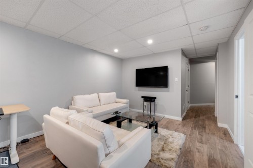 Living area featuring a paneled ceiling and wood finished floors - 81 Richmond Link, Fort Saskatchewan, AB - Indoor